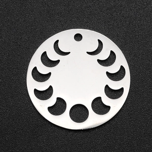 Macro detail of a round stainless steel moon phase pendant with hollow geometric cutouts