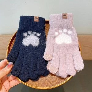 Detail of warm winter knit gloves with bear paw prints and touch screen tips for cold weather