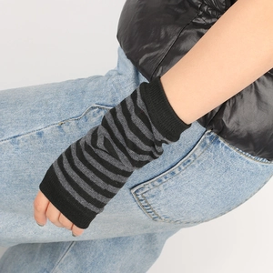 Macro shot of knitted black and grey striped fingerless gloves showing arm coverage