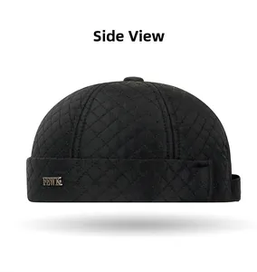 Detail of black quilted skull cap with diamond stitching and FEWK metal brand plate