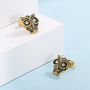 Vue détaillée de boucles d'oreilles hibou dorées avec texture noire et cristaux