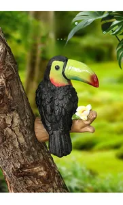 Détail d'une sculpture réaliste de toucan avec bec coloré fixée sur un tronc d'arbre