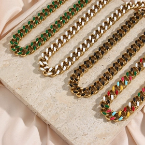 Golden Cuban link necklaces with colorful enamel plating on beige marble background