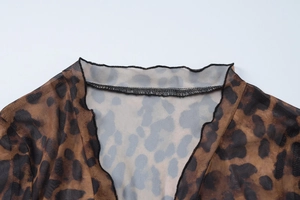Detailed close-up of leopard print sheer mesh fabric neckline with fine stitching