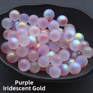 Macro detail of 12mm purple frosted glass beads with gold foil flecks in a bowl