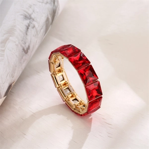 Detail of square-cut red crystals set in gold-tone elastic bracelet with brilliant shine
