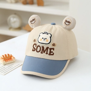 Detail of cartoon bear patch and brown SOME embroidery on kids baseball cap