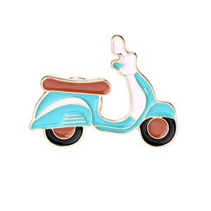 Detailed close-up of blue and brown enamel motorcycle brooch with gold metallic trim