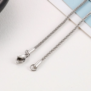 Macro shot of silver woven mesh chain with lobster clasp for stainless steel necklace
