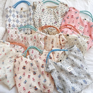 Flat lay of embossed canvas bags featuring floral, bear, and rabbit patterns in pastel colors