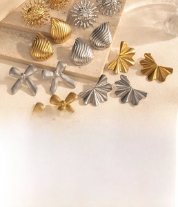 Detailed view of striped bow and teardrop earrings made of vacuum plated titanium steel
