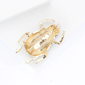Detailed back view of a golden beetle brooch showing the pin clasp and vintage metal texture