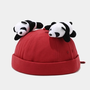 Detailed close-up of a red docker hat featuring cute plush panda toys on the crown