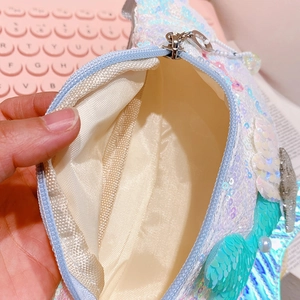 Close-up of the sequin waist bag interior showing fabric lining and zipper closure