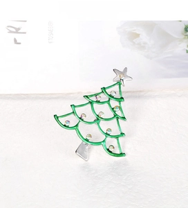 Close-up of green enamel Christmas tree brooch with colorful rhinestones and silver star