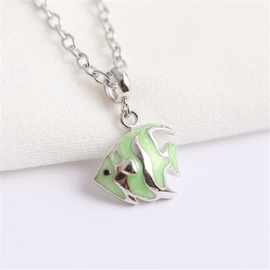 Détail d'un pendentif poisson tropical en émail vert sur une fine chaîne en argent massif