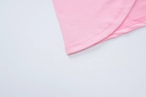 Detailed macro shot of the pink knitted fabric hem with durable double-needle stitching