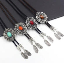 Detail view of four multi-colored gemstone bolo ties with vintage silver feather charms