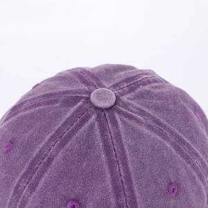 Macro view of purple washed cotton baseball cap with detailed stitching and top button