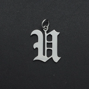 Macro detail of Gothic-style letter V pendant in polished silver stainless steel