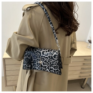 Sac bandoulière chic à imprimé léopard avec étoile argentée porté sur un trench-coat beige
