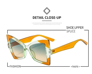 Close-up of butterfly cat-eye sunglasses with green frame and orange contrast details