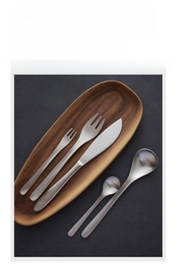 Macro view of matte 304 stainless steel cutlery set on a rustic wooden tray