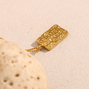 Detail of 18K gold-plated star and moon square pendant with hammered texture design