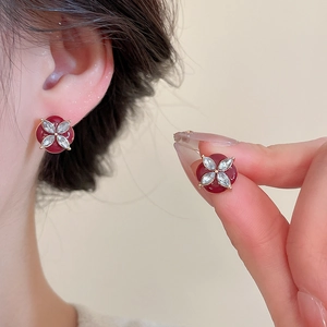 Detail view of red enamel flower studs with clover-shaped cubic zirconia crystals