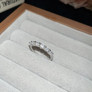 Detailed close-up of a silver band ring with rectangular zircon stones in a jewelry box