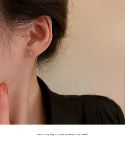 Nahaufnahme eines funkelnden Zirkonia-Ohrsteckers am Ohrläppchen für einen minimalistischen Look