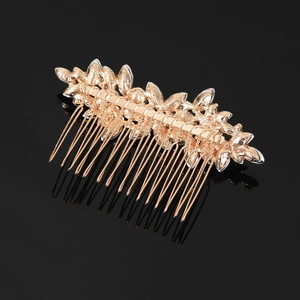 Elegant gold leaf bridal hair comb with crystals and rhinestones on black background