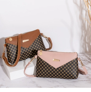Detailed macro view of monogram print crossbody bags with elegant gold metal hardware