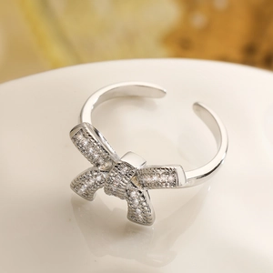 Close-up of elegant silver bow ring featuring sparkling zircon pavé and open band design