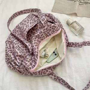 Macro shot showing the spacious interior and zipper pocket of the purple leopard tote bag