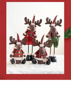 Close-up of plush Christmas reindeer dolls in red and green plaid on white rug