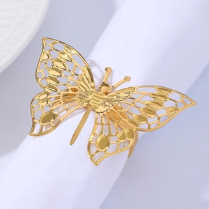 Detail showing elegant gold butterfly napkin ring with hollow design on white cloth