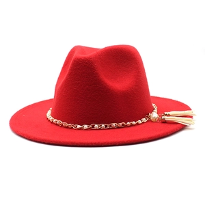 Detail of red wool fedora featuring gold chain, white pearls and beige side tassels