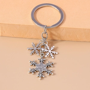 Macro shot of silver vintage snowflake charms on a metallic keychain pendant