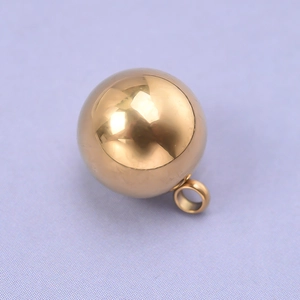 Détail macro du pendentif sphérique en acier inoxydable doré poli avec finition miroir