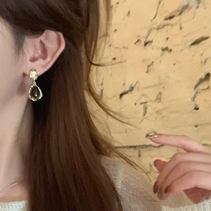 Retro tiger eye flower earrings with amber drop pendants shown on a model side profile