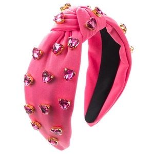 Detailansicht eines rosa Knotenstirnbandes mit herzförmigen Kristallverzierungen