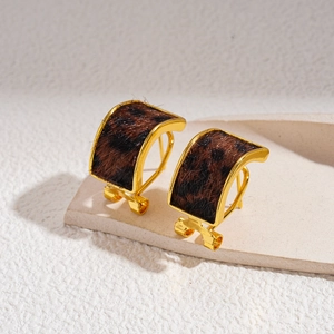 Vintage leopard print horsehair C-shaped gold earrings for women on a stone display