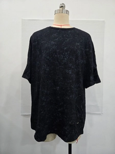Detail shot of distressed vintage black mineral wash T-shirt fabric with ripped accents