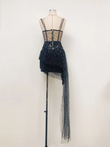 Detail of sheer black mesh dress with sequins and an asymmetrical tulle train