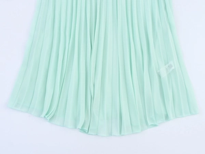 Detail of mint green pleated dress hem showing fine texture and clean stitching