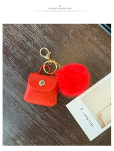 Macro view of red crocodile pattern mini bag keychain with fluffy faux fur pompom