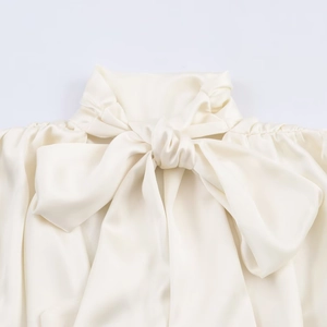 Elegante camicetta in raso avorio con dettaglio fiocco sul collo e texture lucida