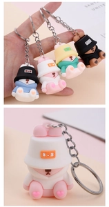 Macro detail of cute PVC bear keychains with fisherman hats and metal hardware
