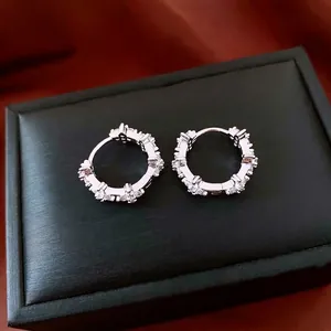 Boucles d'oreilles créoles en argent serties de zircons sur écrin à bijoux noir